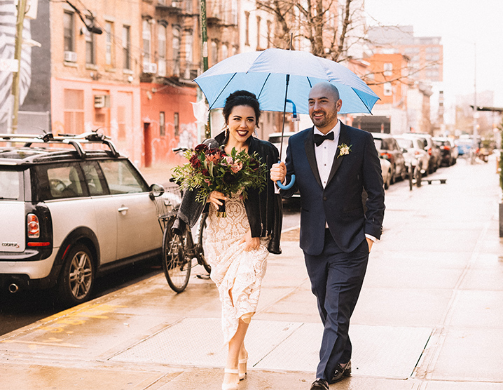 Wedding couple walking down NYC street in the rain