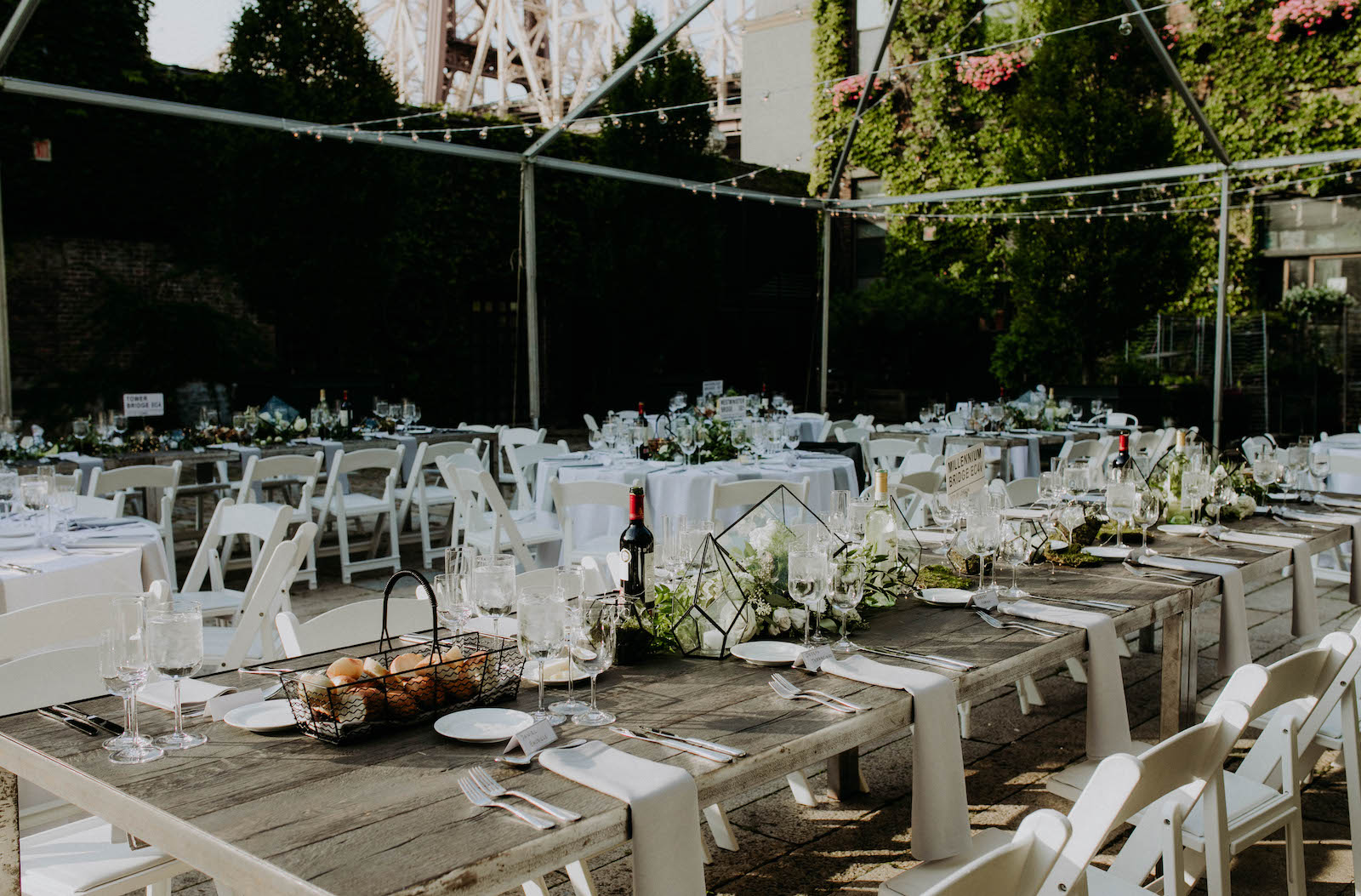 Wedding reception table set up with farm tables in the courtyard of The Foundry in LIC